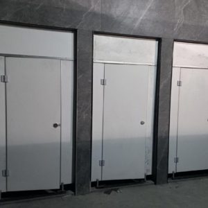 سه کابین سرویس بهداشتی HPL سفید با یراق‌آلات فلزی و دیوارپوش سنگی طوسی