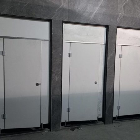سه کابین سرویس بهداشتی HPL سفید با یراقآلات فلزی و دیوارپوش سنگی طوسی