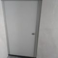 سه کابین سرویس بهداشتی HPL سفید با یراق‌آلات فلزی و دیوارپوش سنگی طوسی
